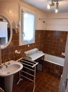 La salle de bains est pourvue d'un lavabo et d'un miroir. dans l'établissement Maison familiale , Mine d'or à pied, à Pénestin