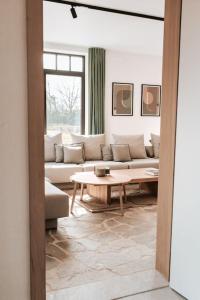 un soggiorno con divano e tavolo di Vakantiewoning Domein Hooverbosch a Zonnebeke