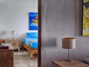 a bedroom with a bed and a table with a lamp at Pandana Boutique Hotel in Nusa Lembongan