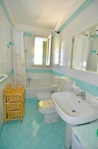 uma casa de banho azul e branca com um lavatório e um WC em Villetta Mary em Torre Vado
