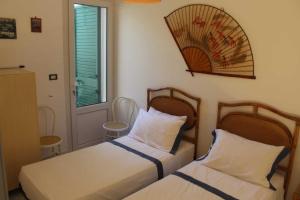um quarto com 2 camas, uma janela e uma porta em Villetta Mary em Torre Vado