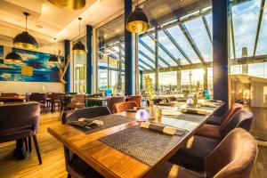 a restaurant with a table and chairs and windows at Lagovida Das Ferienresort Am Störmthaler See in Großpösna +81 photos