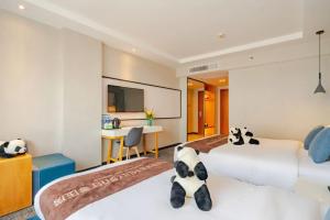 a hotel room with two beds with stuffed animals on them at Chong Li Hotel Chengdu in Chengdu