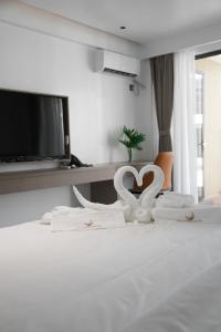 a bedroom with a bed with two white swans on it at Willander Resort in Panglao