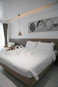 a bedroom with a large white bed with plates on the wall at Willander Resort in Panglao