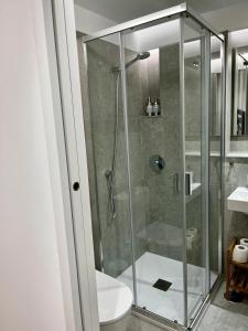 uma casa de banho com uma cabina de duche em vidro e um WC. em Hostal Charo II em Santiago de Compostela