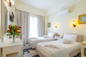 een hotelkamer met 2 bedden en een raam bij Kymata Hotel in Naxos Chora