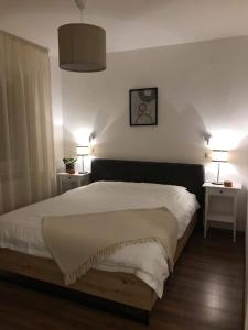 貝羅沃的住宿－赫斯提亞公寓，卧室配有一张带两张桌子的大型白色床