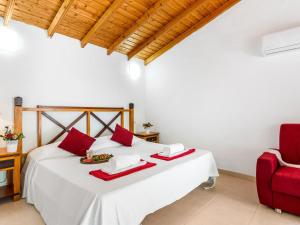 a bedroom with a white bed and a red chair at 102 Bright Accomodation with Pool View in Playa Fañabe