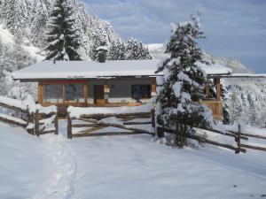 a log cabin in the snow with a fence at Chalet in Niederndorf near Kufstein with balcony in Niederndorferberg