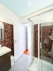 La salle de bains est pourvue d'une douche en verre et d'un lavabo. dans l'établissement Mauremile, à Pella