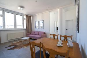 a living room with a table and a purple couch at Old Town Apartment Black in Bratislava