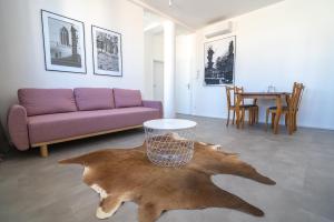 a living room with a purple couch and a table at Old Town Apartment Black in Bratislava +5 photos