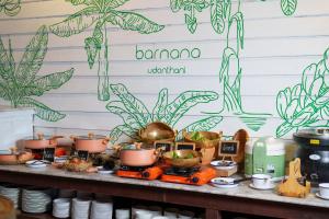 烏隆他尼的住宿－Blu Monkey Brown House Udonthani，餐桌上的自助餐,包括植物和锅