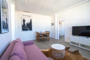 uma sala de estar com um sofá roxo e uma mesa em Old Town Apartment Black em Bratislava