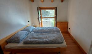 a bed in a room with a window at Ca'Capriolo in Taceno