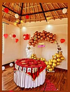 une chambre avec une table et un bouquet de ballons dans l'établissement The royal hut, à Kokkíni Khánion