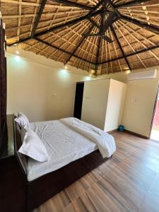 um quarto com uma cama com um telhado de palha em The royal hut em Ajmer