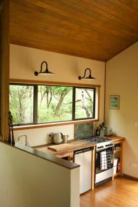 a kitchen with a stove top oven next to a window at Modern, Cosy Hideaway - Rua Nuka Raglan in Raglan