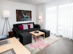 a living room with a black couch and a table at Modern Apartment near Ski Area in Schladming in Rohrmoos