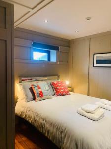 een slaapkamer met een groot bed met kussens erop bij Maisie Ryan's Beach Apartment in Caherdaniel