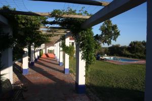 una pérgola con una piscina al fondo en Tarola Place, a unique country house!, en São Cristóvão