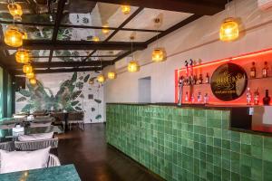 a restaurant with a green tiled counter and a bar at Hotel Orritel West in Mumbai