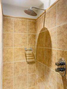 een badkamer met een douche en een betegelde muur bij Maisie Ryan's Beach Apartment in Caherdaniel
