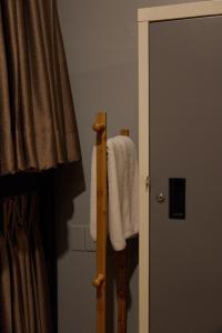 a towel hanging on a towel rack next to a door at Timber Hostel in Bangkok