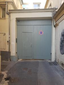 a green garage door with a sign on it at LE PETIT TRIPLEX DES CARMELITES -COEUR HISTORIQUE in Rouen