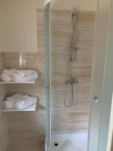 y baño con ducha con puerta de cristal y toallas. en Villa Angela Lucia, en Stomorska
