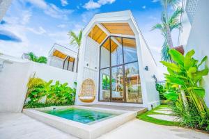 una casa con piscina nel cortile posteriore di The Putih Tiny Villa - Architectural House 4 mins from Beach a Tanah Lot