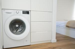 a white washer and dryer in a room at Casa Fuerteremote - new and modern house with office in Corralejo in La Oliva