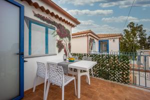a patio with a white table and chairs on a balcony at Acquamarina, appartamenti sul mare con piscina in Cardedu