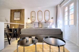 um quarto com uma cama com duas mesas e dois espelhos em Studio de Luxe au Cœur de Grasse em Grasse