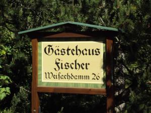 a sign for a restaurant in front of a tree at Gästehaus Fischer in Rottach-Egern