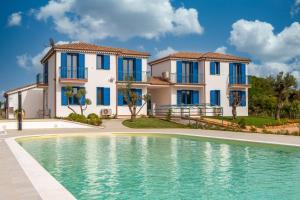 a villa with a swimming pool in front of a house at Acquamarina, appartamenti sul mare con piscina in Cardedu