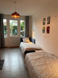 twee bedden in een kamer met een raam bij Au 154 Bis - Bel appartement - Le Jardin in Duinkerke