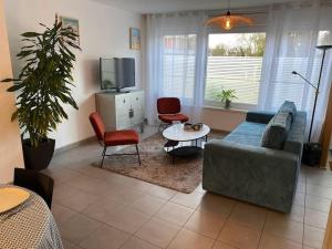 a living room with a couch and chairs and a tv at Au 154 Bis - Bel appartement - Le Jardin in Dunkerque