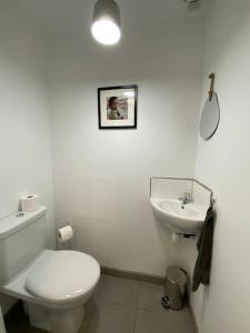 a white bathroom with a toilet and a sink at Au 154 Bis - Bel appartement - Le Jardin in Dunkerque