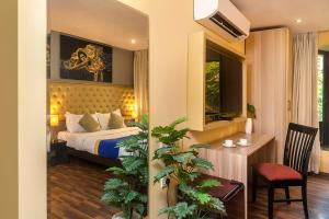 a bedroom with a bed and a desk with a chair at Hotel Orritel West in Mumbai