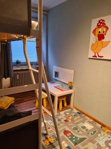 a childs bedroom with a bunk bed with a desk at Waldblick Ferienwohnungen in Bonndorf im Schwarzwald