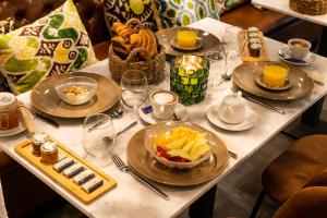 Boutique Hotel Casa Cánovas في كاديز: طاولة بيضاء عليها صحون طعام