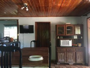 eine Küche mit einem Holztisch und einer Mikrowelle in der Unterkunft Ninho da Águia; Espetáculo da natureza in Poços de Caldas