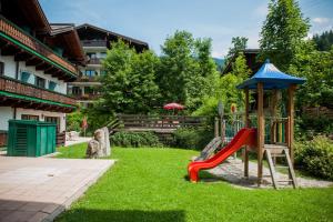 un parque infantil en un patio con tobogán en Hotel Kirchboden by Alpeffect Hotels, en Wagrain