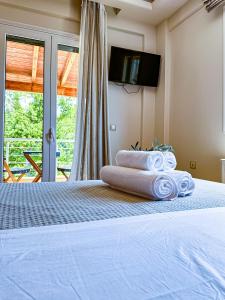 a bedroom with a bed with towels on it at Catherine Luxury Holiday House close to Corfu Town in Potamós