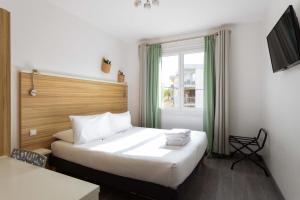 a hotel room with a bed and a window at L'Oasis Hotel in Fréjus