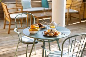 una mesa azul con platos de comida. en L'Oasis Hotel, en Fréjus