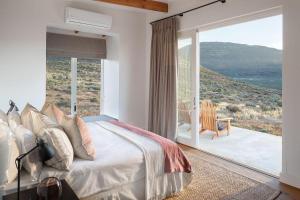 a bedroom with a large bed and a large window at Simbavati Cederberg Ridge in Clanwilliam