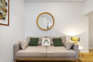 a living room with a couch and a mirror at Cozy Apt in Lisbon with Terrace by Soulplaces in Lisbon
